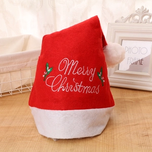 Bonnet de Noël classique rouge et blanc avec broderie Merry Christmas sur table en bois
