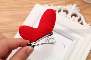 Detail of red plush heart hair clip with silver metal alligator base for festive party hair