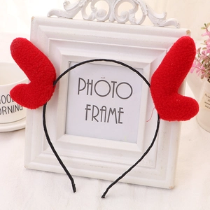 Detailed view of handmade plush red reindeer antlers on a flexible black headband