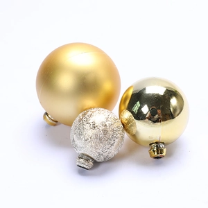 Macro detail of Christmas cake topper balls in gold matte, glossy, and silver textures
