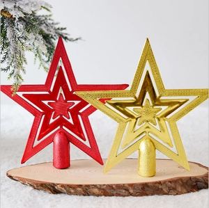 Detail of red and gold glittery hollow star tree toppers on rustic wood surface