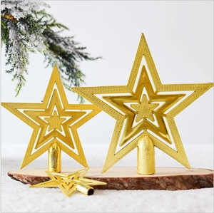 Detailed view of three sizes of gold hollow star Christmas tree toppers on pine branches