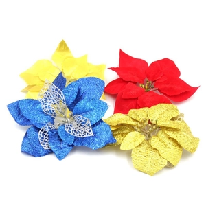 Close-up of glittery artificial poinsettia flowers in red, blue, and gold for tree decor