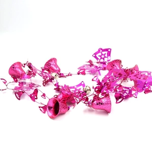 Close-up of metallic rose red Christmas ornaments with shiny bells and snowflake cutouts