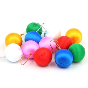 Close-up of colorful silk-wrapped Christmas tree baubles with gold and silver hanging loops