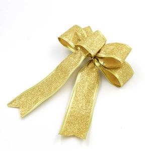 Close-up of golden glitter bow decoration for Christmas tree or gift packaging adornment