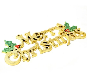 Golden Merry Christmas sign detail with green holly leaves and red berries for tree decor