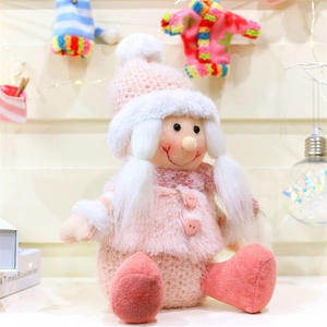 Dettaglio di una bambola di Natale rosa con cappello di maglia bianco e cuore