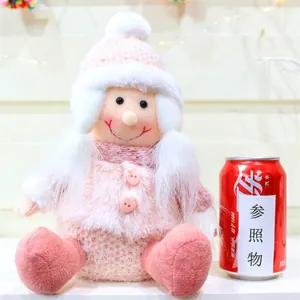 Dettaglio di una bambola in maglia rosa con cappello e sciarpa, stile regalo invernale