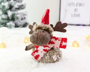 Detailed close-up of a plush reindeer ornament with a red hat and knit snowflake scarf