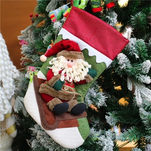 Chaussette de Noël rouge avec poupée Père Noël 3D accrochée sur un sapin de Noël festif