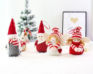 Detailed view of five plush Christmas ornaments with red strings on a snowy background