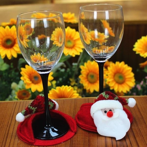 Detail of Christmas wine glass covers featuring Santa Claus decor on black stems