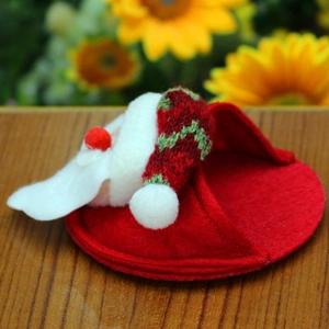 Macro shot of handmade felt Santa Claus coaster with red knit hat and white fuzzy pompom