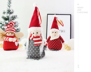 Macro detail of red knitted Santa Claus plush ornament with hanging loop on a Christmas tree