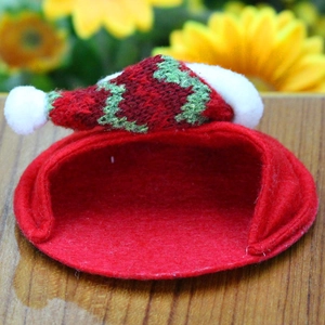 Close-up of a festive red felt Christmas hat with colorful knit mini cap for pets