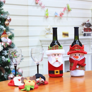 Detail of Santa and snowman wine bottle covers with matching coasters on festive table
