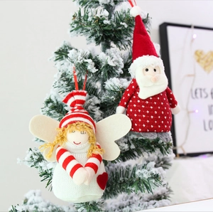 Plush Santa and Angel ornaments in red and white hanging on a snowy Christmas tree branch