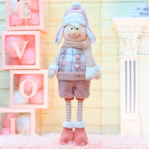 Détail d'un lutin de Noël en peluche rose avec bonnet tricoté et boutons en cœur