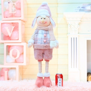 Détail d'une poupée de Noël rose avec écharpe tricotée et boutons en forme de cœur