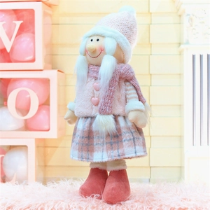 Détail macro d'une mignonne poupée de Noël rose avec bonnet tricoté et gilet