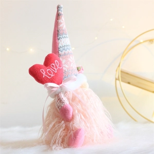 Close-up of pink Valentine gnome plush with heart and Love embroidery decoration
