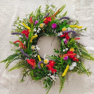 Artificial Texas wildflower wreath with red geraniums and lavender on lace tablecloth