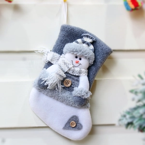 Plush Christmas stocking with snowman, gray and white hanging decoration on wood wall