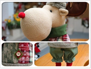 Détails d'une peluche de renne avec nez rouge, tenue à carreaux et boutons en bois