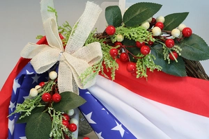 Detail of USA Independence Day wreath with burlap bow and patriotic berry accents
