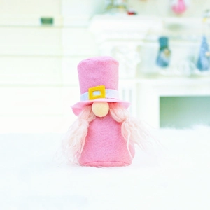 Close-up of pink felt gnome decoration with white faux fur beard and yellow buckle