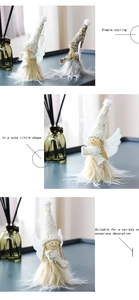 Détail d'une poupée d'ange de Noël en tricot blanc avec bordure en peluche et ailes en plumes