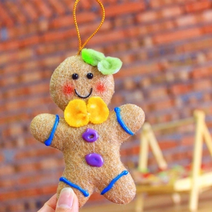 Handheld ginger bread man Christmas tree hanging ornament with a cute yellow bow tie