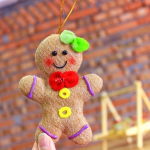 Gingerbread man chef gnome plush ornament with red bow and gold hanging string