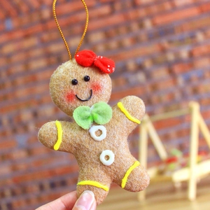 Detailed view of handmade gingerbread man ornament with red bow and festive textures