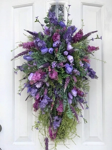 Detail of purple tulip and lavender teardrop wreath hanging on a white wooden door