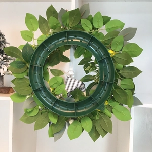 Artificial yellow rose and lemon wreath with green foliage and striped ribbon decoration