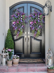 Symmetric purple tulip and lavender door swags with green ivy on black front door