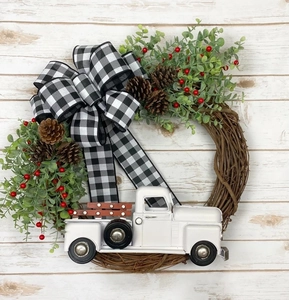 Détail d'une couronne de Noël avec camion vintage, feuilles d'eucalyptus et pommes de pin