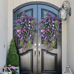 Symmetric purple tulip and lavender teardrop wreaths on black double front doors