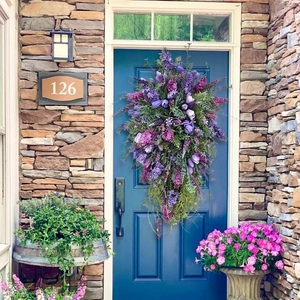 Floral teardrop wreath with purple tulips and lavender hanging on a blue front door