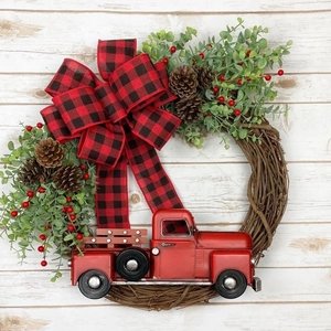 Couronne de Noël avec camion rouge nœud vichy et pommes de pin sur bois blanc