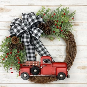 Couronne de Noël avec camion rouge vintage, pommes de pin et nœud sur fond en bois blanc