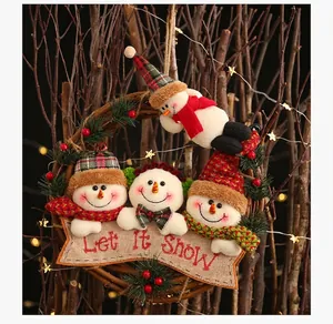 Close-up of Christmas rattan wreath with plush snowmen and Let It Snow banner detail