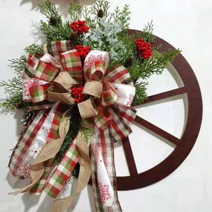 Christmas pine cone wreath with wooden wagon wheel, evergreen branches and plaid bow