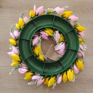 Rear view of artificial tulip wreath with sturdy green plastic frame and burlap ribbon deco
