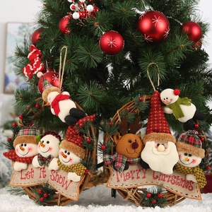Close-up of Christmas wreath with snowman and reindeer plush on natural rattan and burlap sign