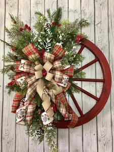 Close-up of Christmas wreath with wooden wheel, pine cones, berries and plaid ribbons