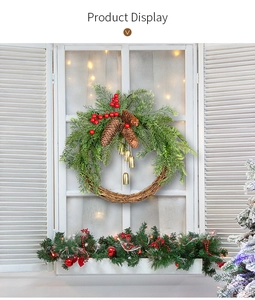 Detail of Christmas wreath with pine cones and gold bells hanging on a white window