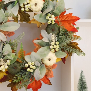 Fall wreath with cream pumpkins and maple leaves for Halloween door decoration